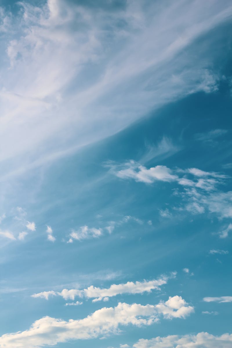 Peaceful sky with wispy clouds drifting in the blue, evoking serenity and calmness.